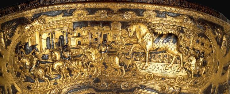 16th-Century saddle shows the Trojans bringing the wooden horse into their city, unaware of the Greek enemies hidden inside. Ambrosiana Gallery, Milan