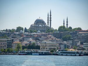 Süleymaniye Mosque with its domes and four minarets above the Golden Horn in Istanbul, with ferries in front
