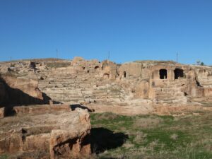 Rock-cut tombs and stepped stone terraces of the necropolis at the ancient city of Dara in Mardin Province under a clear blue sky